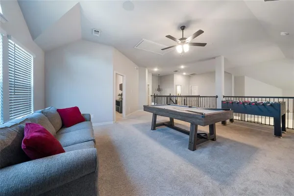 a living room with furniture and a ceiling fan