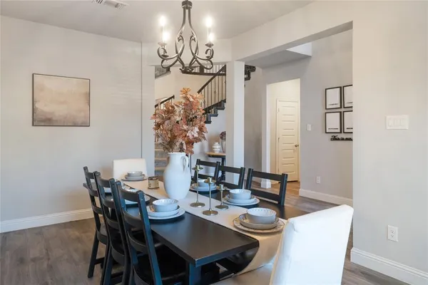 a view of a dining room with furniture a chandelier and wooden floor