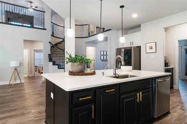 a kitchen with a sink a counter space appliances and cabinets