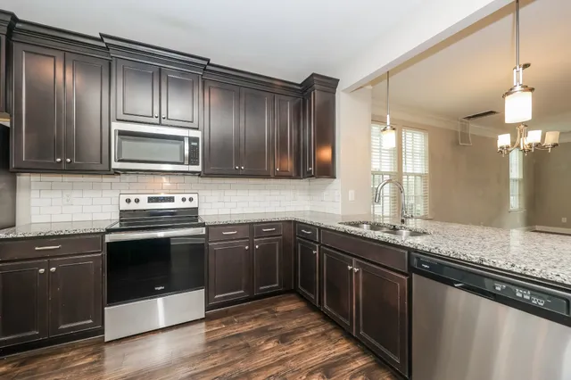 a kitchen with granite countertop stainless steel appliances and wooden cabinets