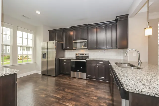 a kitchen with granite countertop stainless steel appliances and wooden cabinets