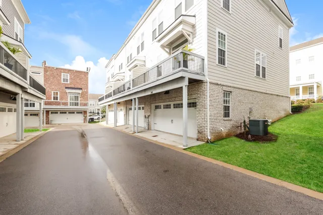 a view of a white house with a big yard and large tree