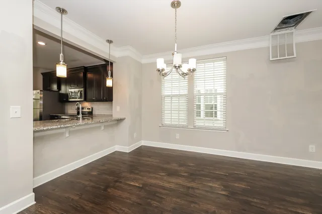 a kitchen with stainless steel appliances granite countertop a sink cabinets a stove and a wooden floor