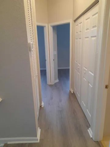 a view of a hallway with wooden floor