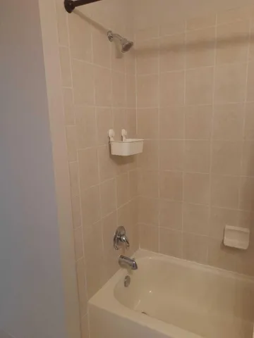 a bathroom with a white bath tub and a shower