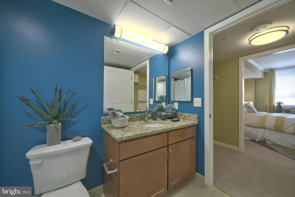 a bathroom with a granite countertop sink a toilet and a mirror