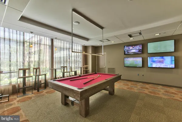 a room with gym equipment pool table and windows