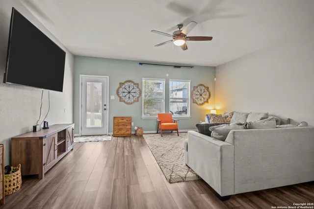 a living room with furniture floor to ceiling window and a flat screen tv