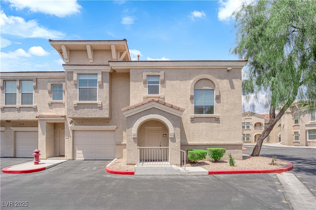 10550 West Alexander Road, Unit 2079 Las Vegas, NV 89129 - Photo 1 of 40 Townhome / multi-family property featuring stucco siding, a garage, and driveway
