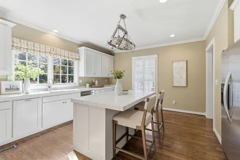 a kitchen with stainless steel appliances a table and chairs in it