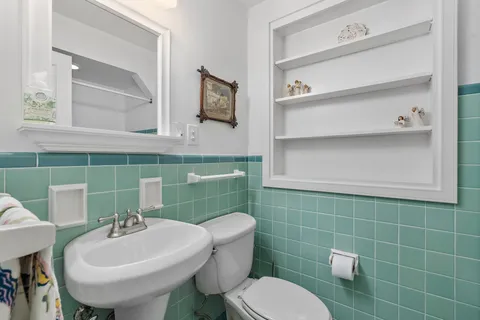 a bathroom with a sink a toilet and mirror