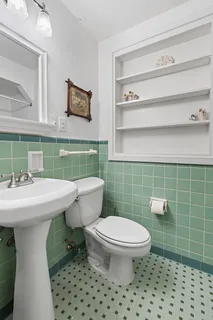 a bathroom with a sink a toilet and a mirror