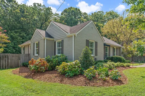 a front view of house with a garden