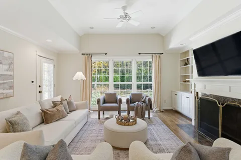 a living room with furniture a flat screen tv and a fireplace