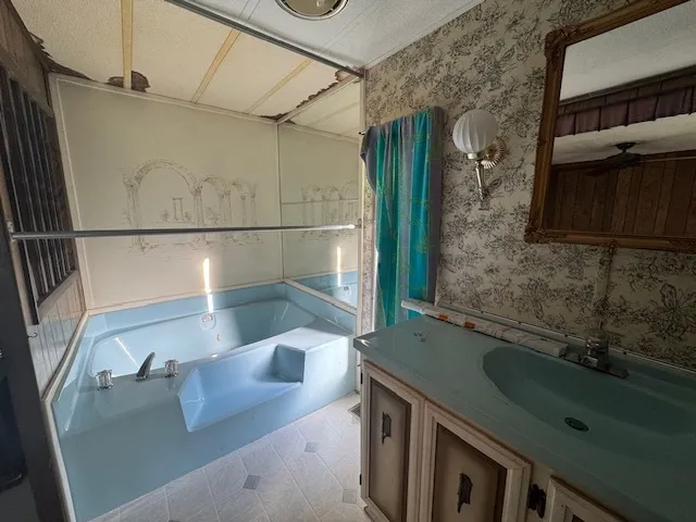 a bathroom with a granite countertop sink a mirror a vanity and shower