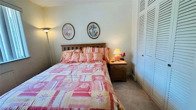 a bedroom with a bed and a lamp on dresser