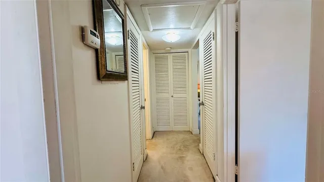 a view of a hallway with wooden floor and a bathroom
