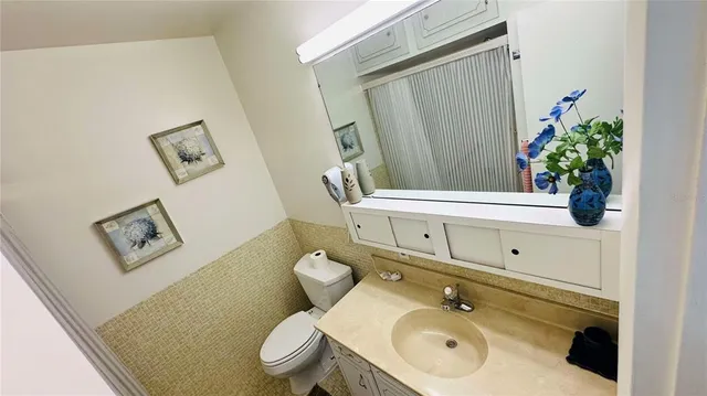 a bathroom with a sink mirror vanity and toilet