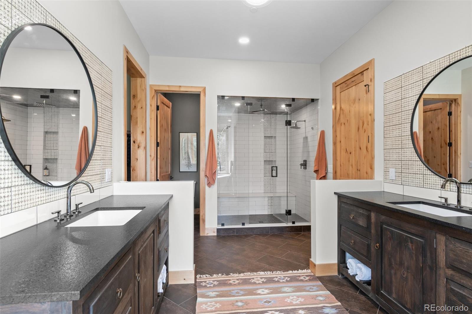 25350 Ridge Way Golden, CO 80401 - Photo 22 of 47 a bathroom with a sink a mirror a vanity and a shower
