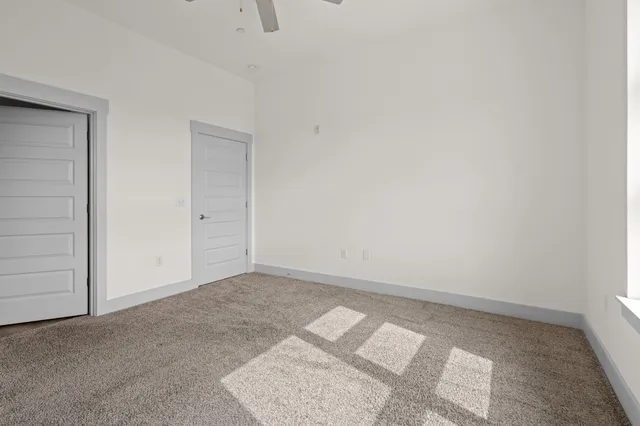 an empty room with closet and windows