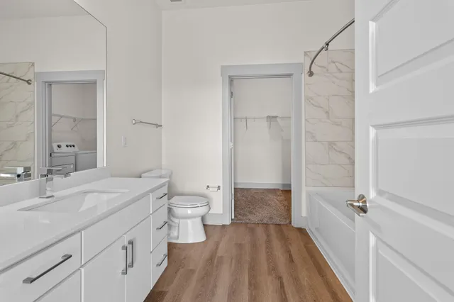 a spacious bathroom with a toilet sink and a mirror