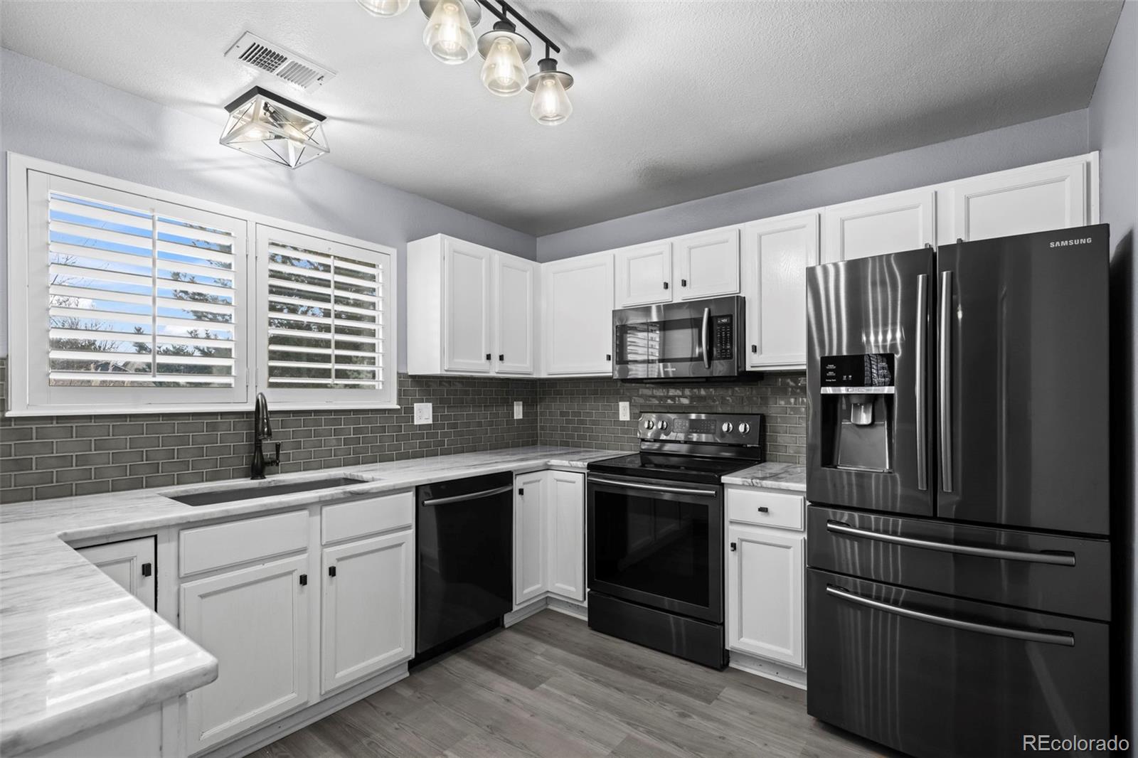 9664 Whitecliff Place Highlands Ranch, CO 80129 - Photo 11 of 46 a kitchen with a sink stove and refrigerator