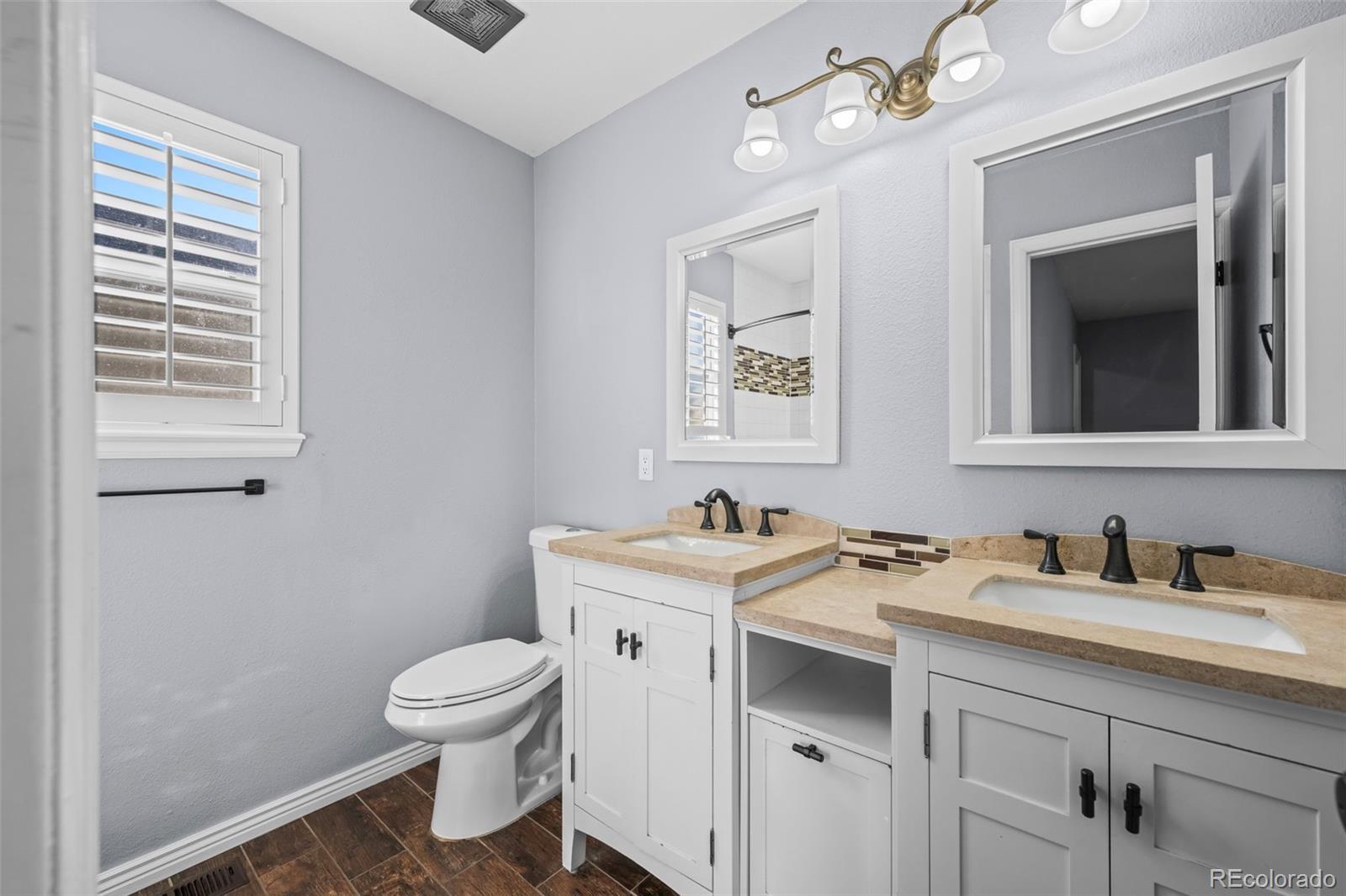 9664 Whitecliff Place Highlands Ranch, CO 80129 - Photo 11 of 38 a bathroom with a toilet a sink and mirror
