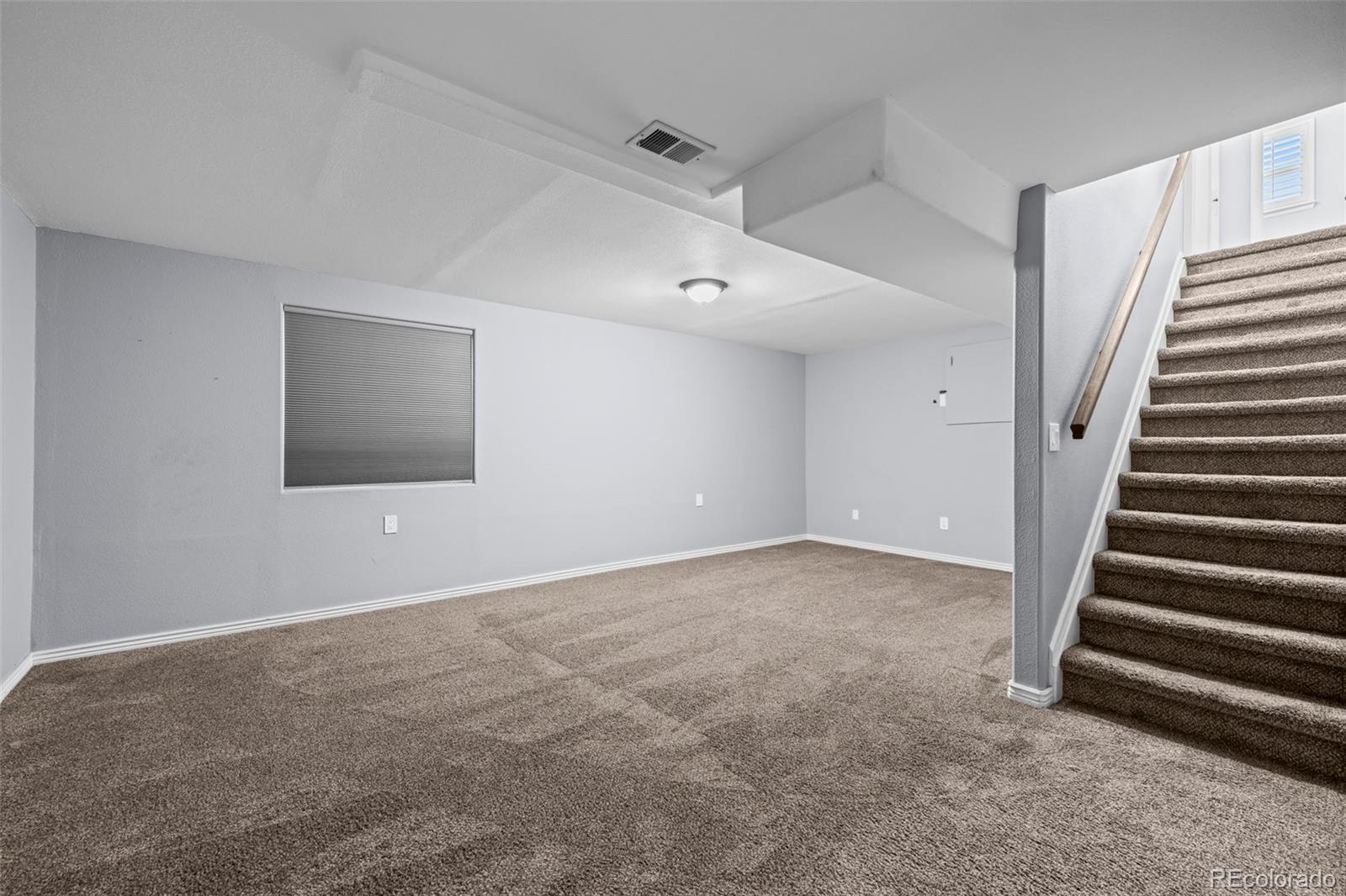 9664 Whitecliff Place Highlands Ranch, CO 80129 - Photo 20 of 46 a view of an empty room with stairs and a ceiling fan