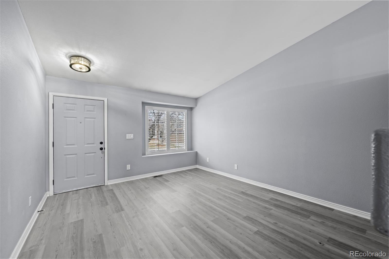 9664 Whitecliff Place Highlands Ranch, CO 80129 - Photo 2 of 46 an empty room with wooden floor and windows