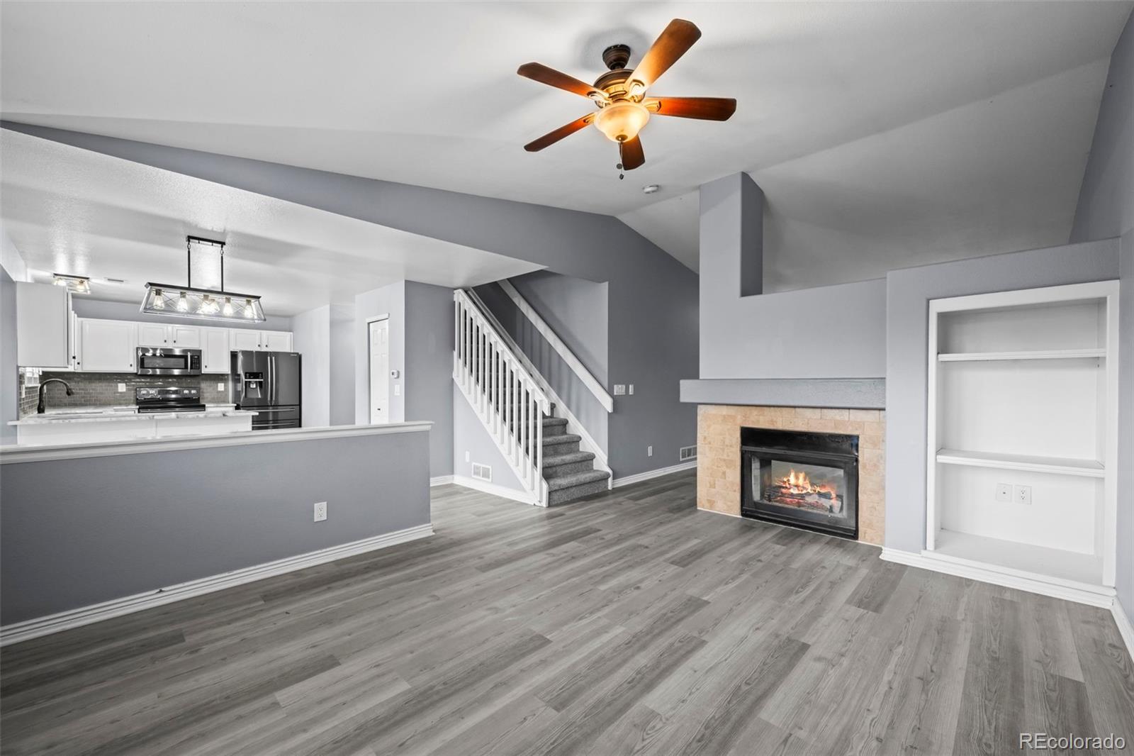 9664 Whitecliff Place Highlands Ranch, CO 80129 - Photo 6 of 46 a view of a kitchen with wooden floor and a fireplace