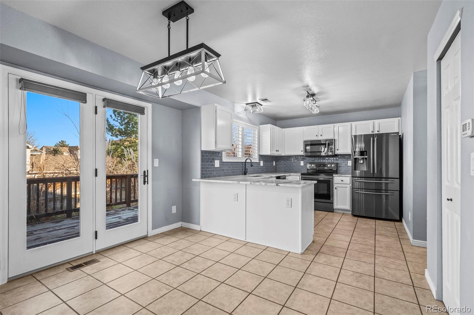 9664 Whitecliff Place Highlands Ranch, CO 80129 - Photo 7 of 38 a kitchen with a refrigerator a stove top oven a sink and cabinets