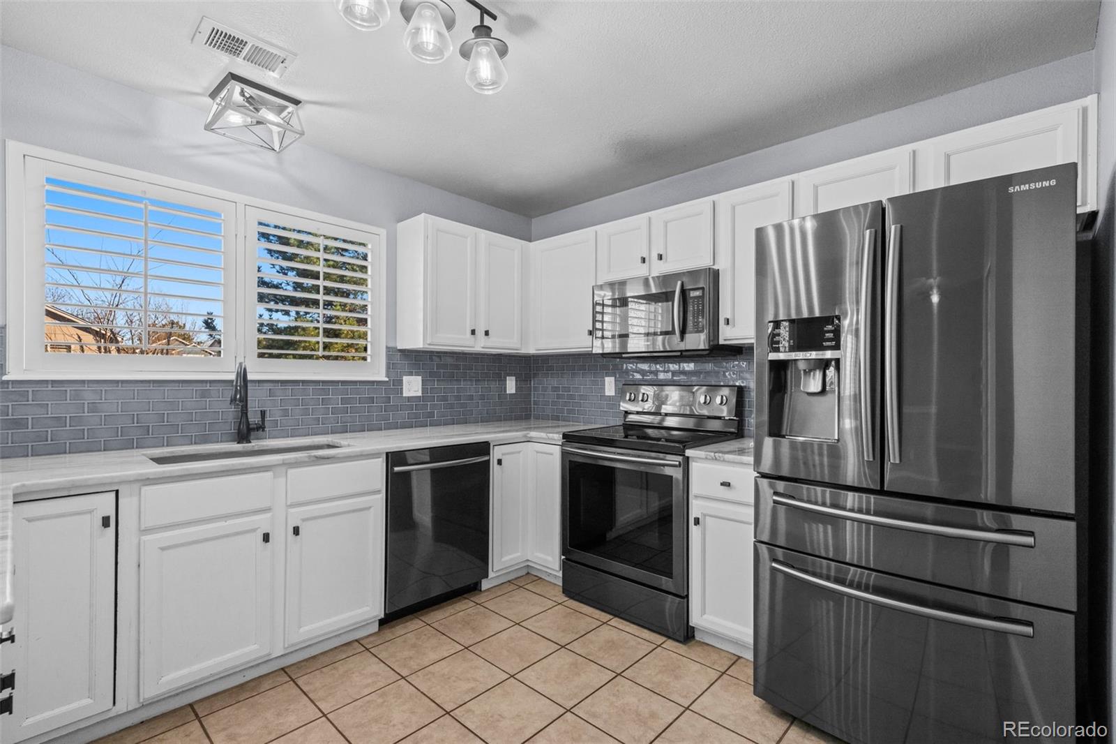 9664 Whitecliff Place Highlands Ranch, CO 80129 - Photo 8 of 38 a kitchen with stainless steel appliances granite countertop a refrigerator stove and sink
