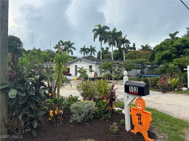 a front view of a house with a yard and tree s