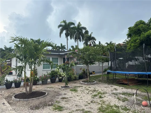 a view of a house with a yard and potted plants