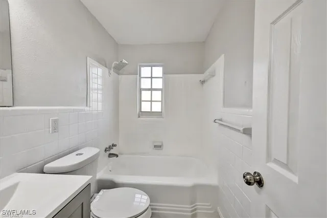a bathroom with a toilet bathtub window and shower