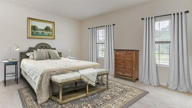 a large bed sitting in a bedroom next to a lamp