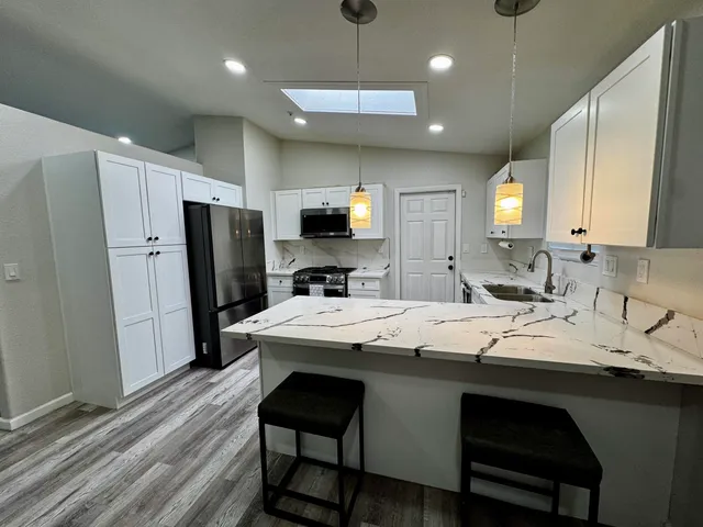 a kitchen with kitchen island a sink stove and refrigerator