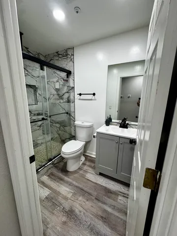a bathroom with a sink a toilet a mirror and shower