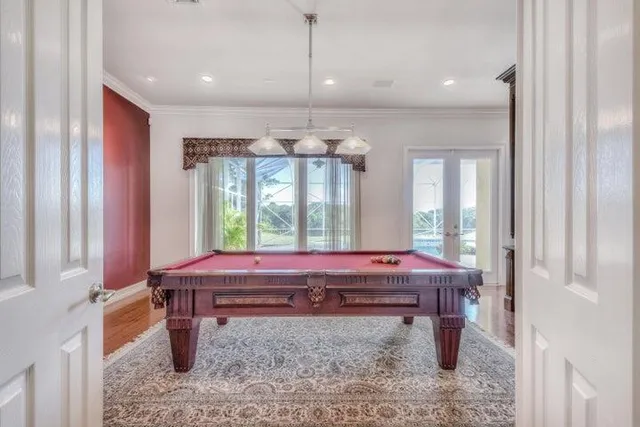 a room with pool table and windows