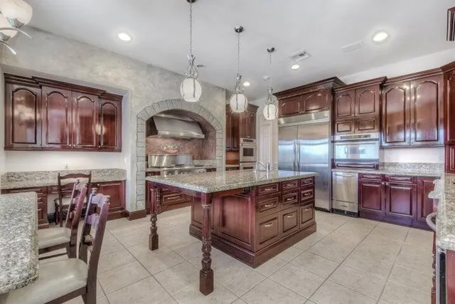 a kitchen with stainless steel appliances granite countertop a stove and a refrigerator