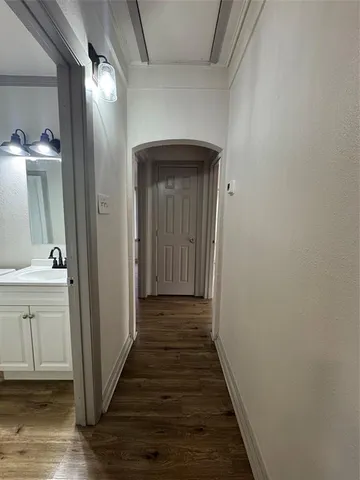 a view of a hallway with wooden floor