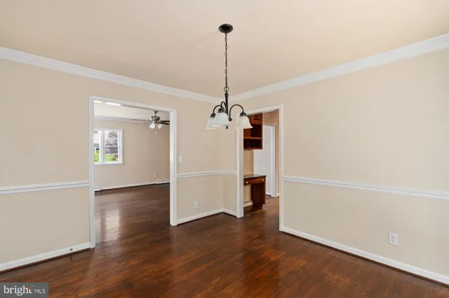 a view of a room with wooden floor and a ceiling fan