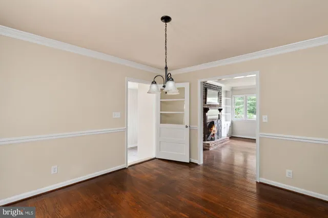 a view of a room with wooden floor and a ceiling fan