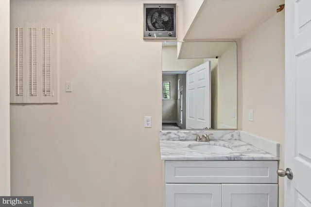 a bathroom with a granite countertop sink and a mirror
