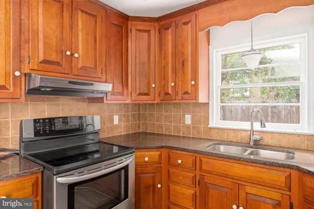 a kitchen with granite countertop cabinets stainless steel appliances and a sink