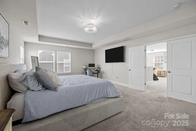 a bed sitting in a bedroom next to a window