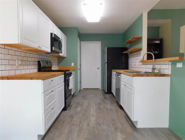 a kitchen with stainless steel appliances a sink stove and cabinets