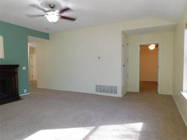 an empty room with a ceiling fan and a window