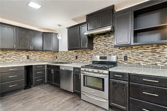 a kitchen with stainless steel appliances wooden cabinets and a stove top oven