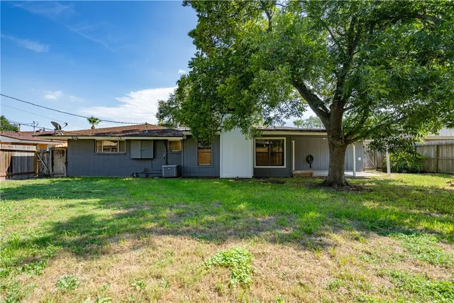 a view of a yard in front of a house with large tree